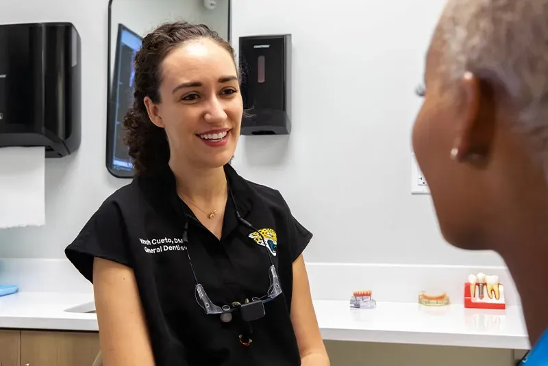 Dental professional explaining the oral cancer screening procedure to a patient